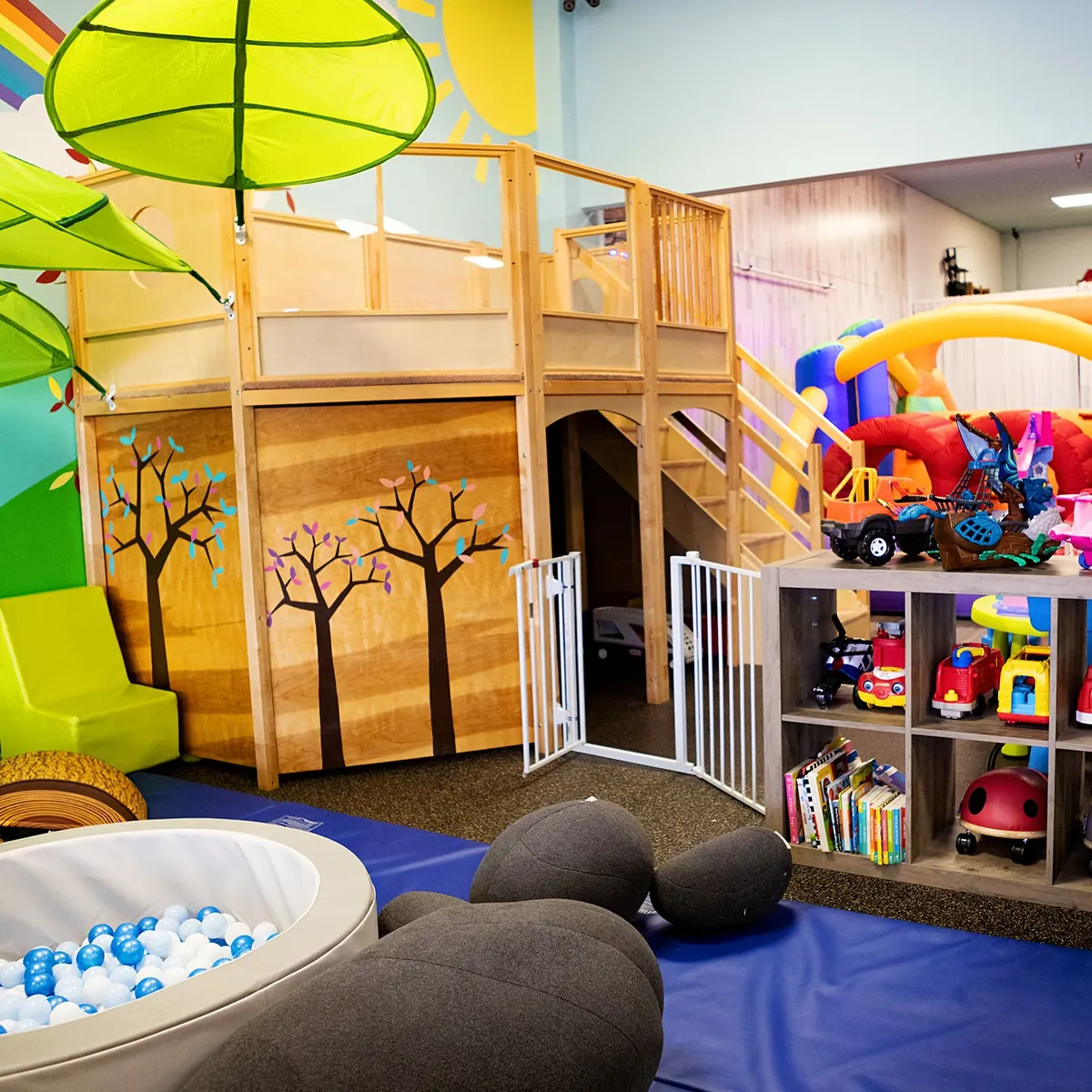 The dedicated under-2 soft play area at Millie Moo's with a mini ball pit under a leaf canopy